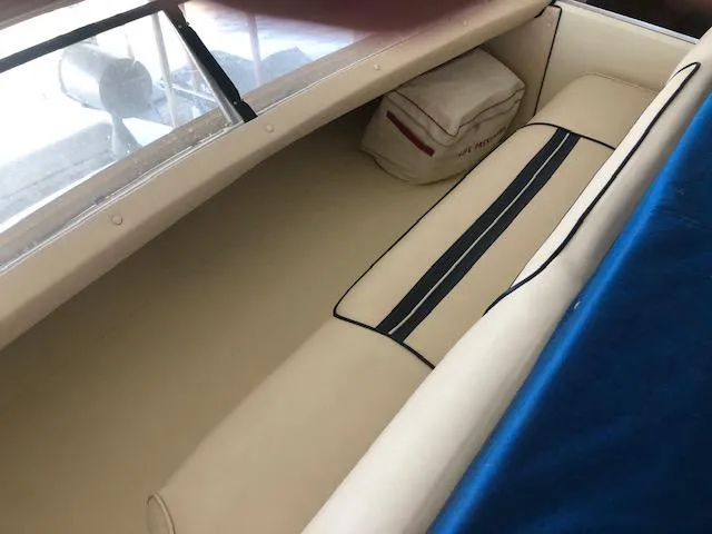 Slide: The Image of 1983 Sea Ray 390 Sport Fisherman interior seating area with cushion and storage. - 12