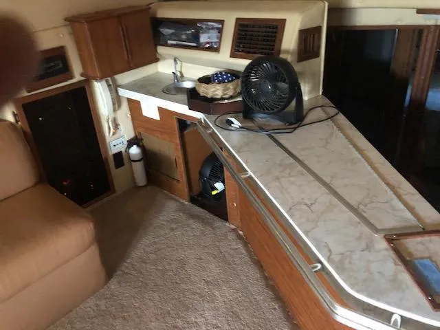 Slide: The Image of Interior of 1983 Sea Ray 390 Sport Fisherman with kitchenette and seating area. - 14