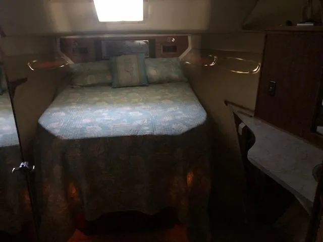 Slide: The Image of 1983 Sea Ray 390 Sport Fisherman cabin interior with bed and window. - 26