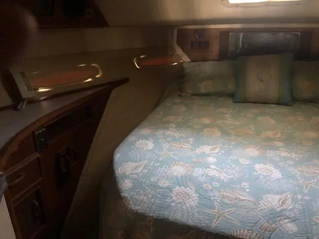Slide: The Image of 1983 Sea Ray 390 Sport Fisherman cabin with bed and nautical-themed bedding. - 29