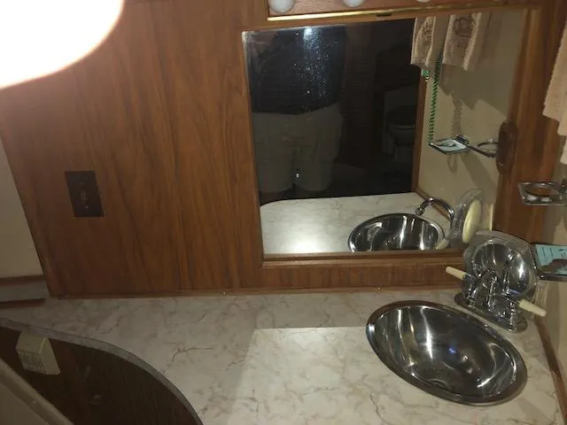 Slide: The Image of 1983 Sea Ray 390 Sport Fisherman bathroom with sink, mirror, and marble countertop. - 31