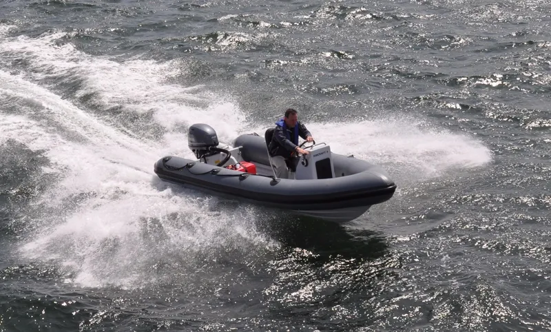 The Image of 2024 Ribcraft 4.8 Coach RIB boat speeding on water. - 1
