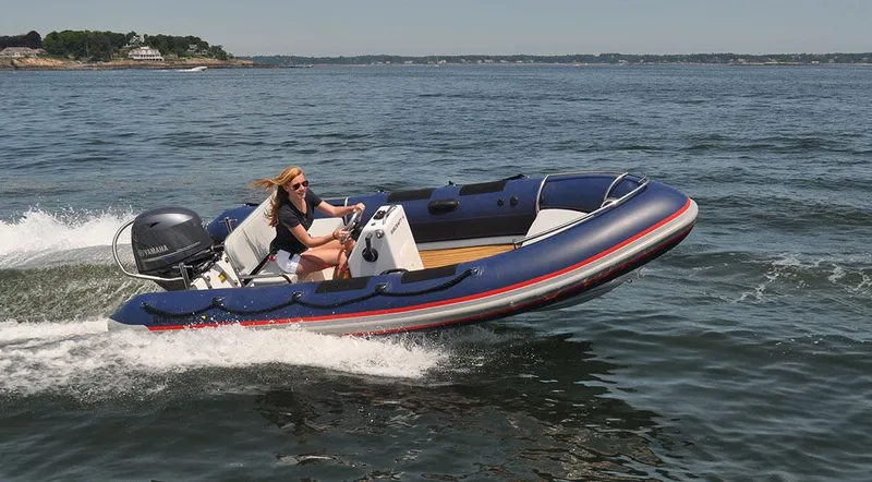 Slide: The Image of 2024 Ribcraft 4.8T inflatable boat speeding on open water. - 3
