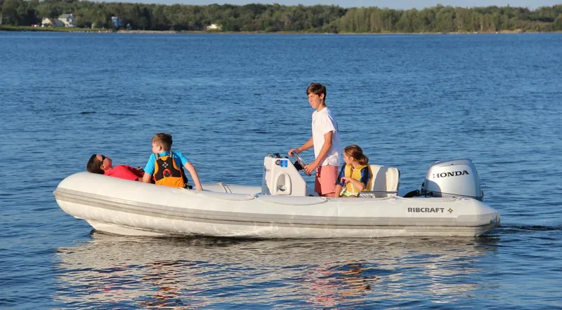 Slide: The Image of 2024 Ribcraft 4.8T inflatable boat with family enjoying a ride on the water. - 4