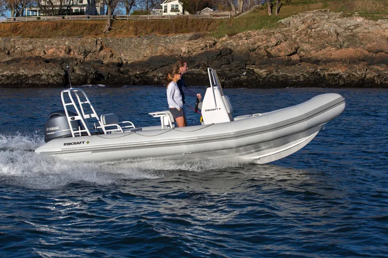 Slide: The Image of 2024 Ribcraft 5.85 boat cruising on water near rocky shoreline. - 3