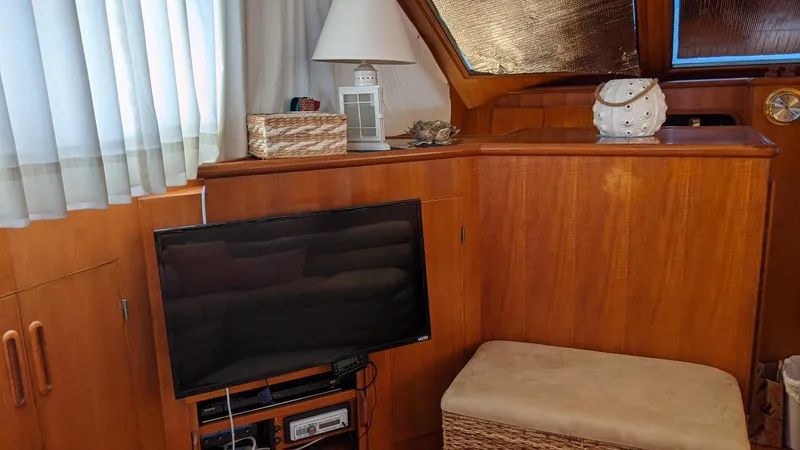 Slide: The Image of Interior of a 1992 Jefferson 43 Sun Deck yacht with TV and wooden furnishings. - 28