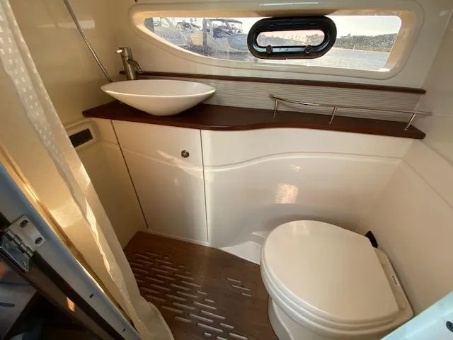 Slide: The Image of Luxurious bathroom in 2015 Sea Ray 350 Sundancer yacht with modern fixtures and porthole view. - 16