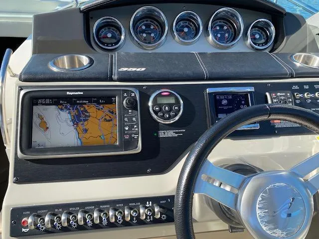Slide: The Image of Dashboard of a 2015 Sea Ray 350 Sundancer with navigation system and controls. - 4