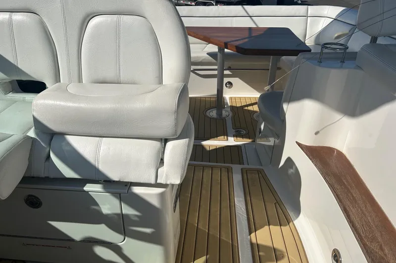 Slide: The Image of Interior of 2015 Sea Ray 350 Sundancer with white seating and wooden table. - 8