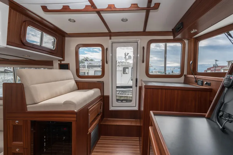 Slide: The Image of 2025 Nordic Tug 40 interior with wooden finishes and large windows. - 11