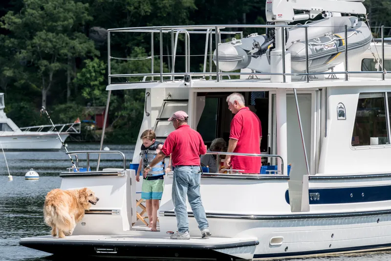 Slide: The Image of Family enjoying a day on a 2025 Nordic Tug 40 boat with their dog. - 13