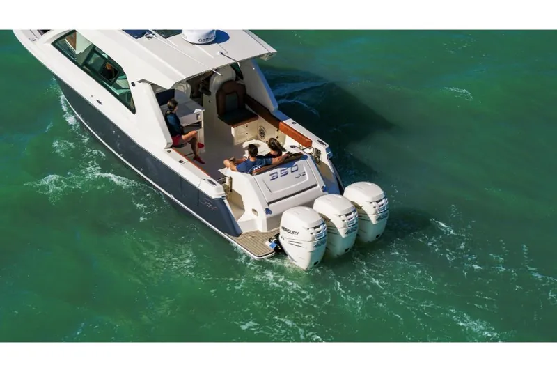 Slide: The Image of 2023 Scout 350 LXZ boat cruising on green water with triple outboard engines. - 13