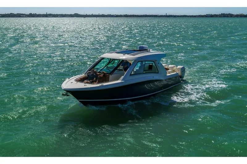 Slide: The Image of 2023 Scout 350 LXZ boat cruising on open water. - 14