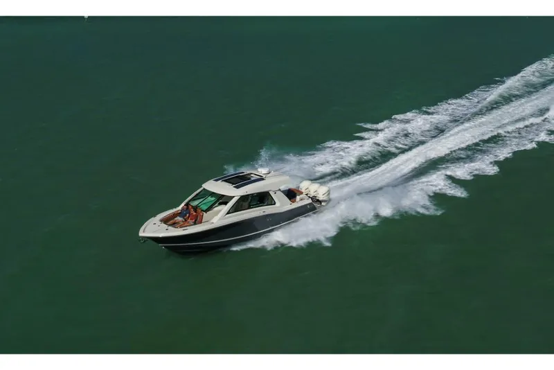 Slide: The Image of 2023 Scout 350 LXZ boat cruising on open water. - 18