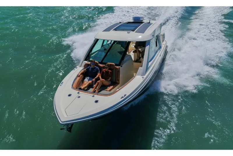 Slide: The Image of 2023 Scout 350 LXZ luxury boat cruising on open water. - 2