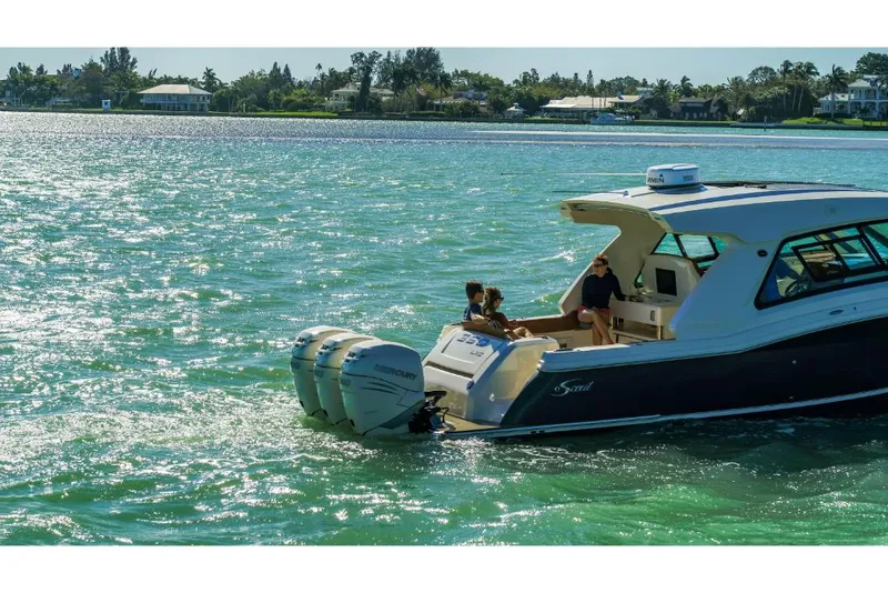 Slide: The Image of 2023 Scout 350 LXZ boat cruising on a sunny day. - 22