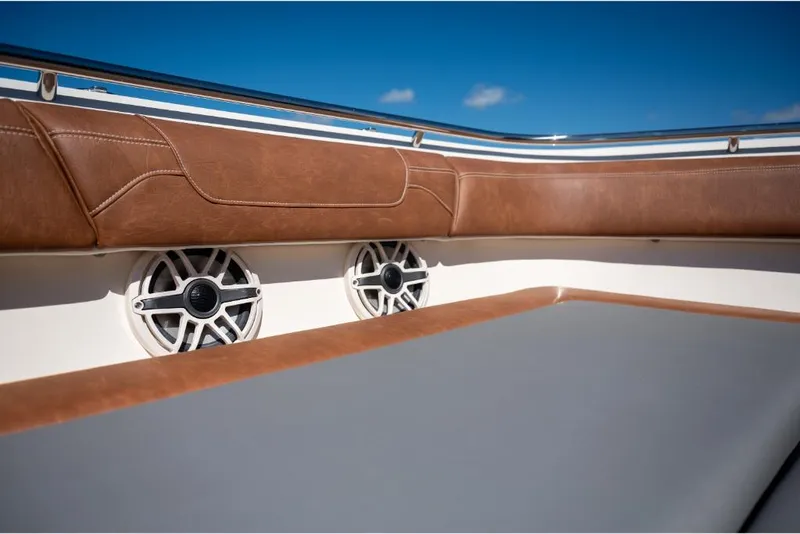 Slide: The Image of 2023 Scout 350 LXZ boat interior with brown leather seating and built-in speakers. - 28
