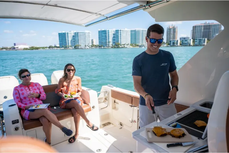 Slide: The Image of People enjoying a barbecue on a 2023 Scout 350 LXZ boat. - 31