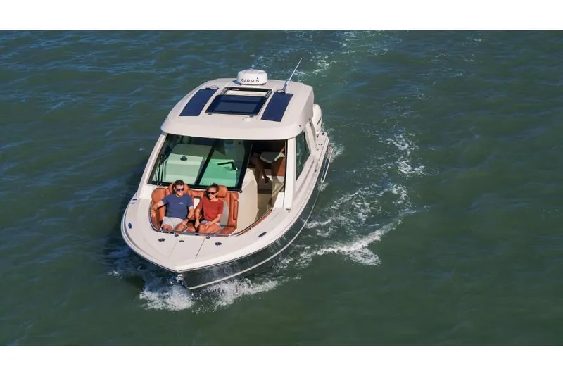 Slide: The Image of 2023 Scout 350 LXZ boat cruising with passengers on a sunny day. - 4