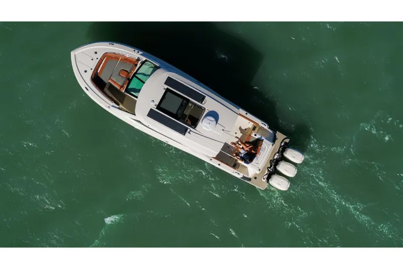 Slide: The Image of 2023 Scout 350 LXZ luxury boat cruising on open water. - 8