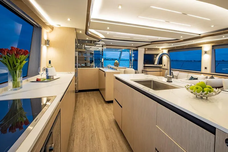 Slide: The Image of Luxurious interior of the 2023 Aquila 70 Luxury yacht with modern kitchen and scenic ocean view. - 18