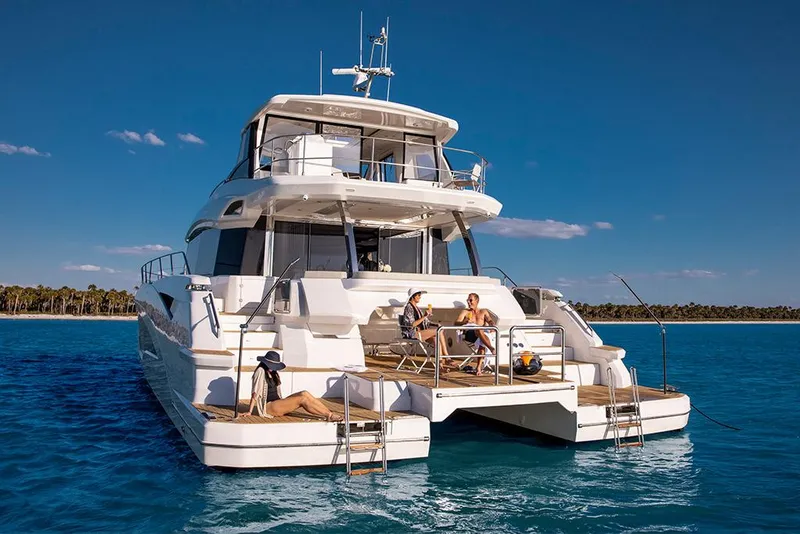 Slide: The Image of 2023 Aquila 70 Luxury yacht anchored with people relaxing on deck. - 6