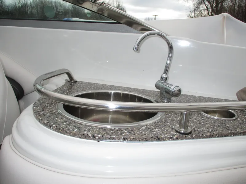Slide: The Image of Crownline 285 SS 2015 boat kitchenette with stainless steel sink and faucet. - 15