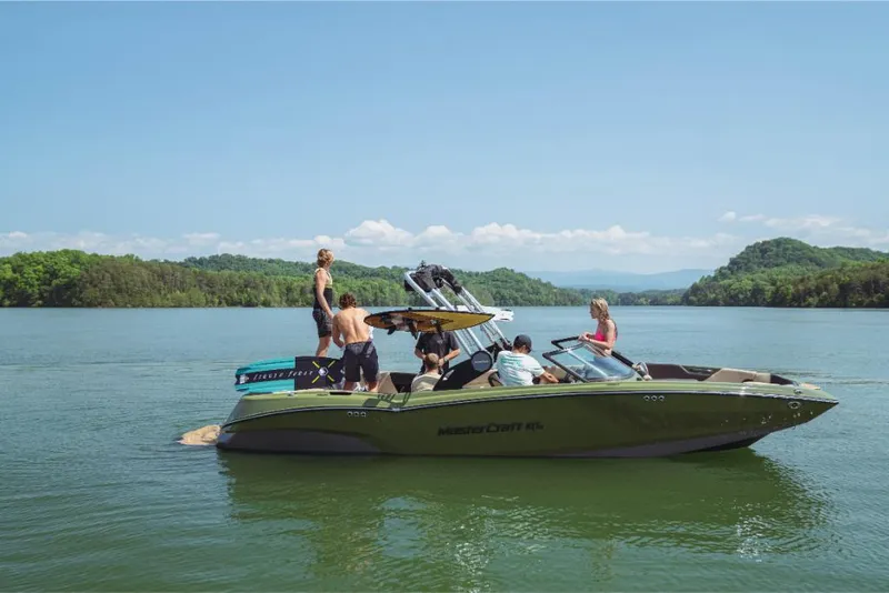 Slide: The Image of 2023 MasterCraft NXT24 boat with people enjoying a sunny day on the lake. - 0