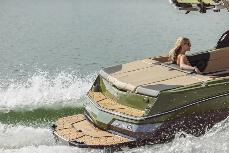 Slide: The Image of 2023 MasterCraft NXT24 boat cruising on water with a woman relaxing. - 11