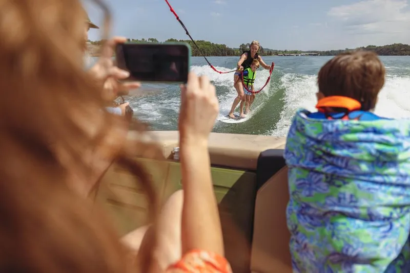 Slide: The Image of People wakeboarding behind a 2023 MasterCraft NXT24 boat on a sunny day. - 12