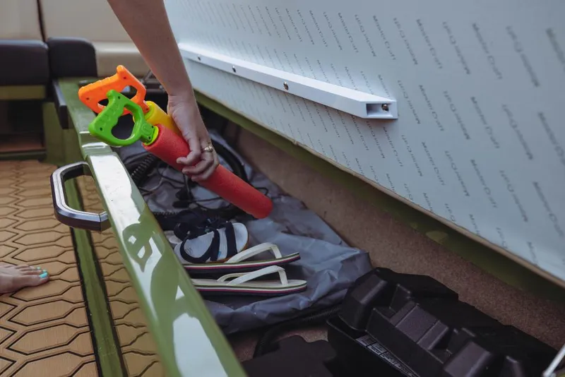 Slide: The Image of Person organizing storage compartment on 2023 MasterCraft NXT24 boat. - 15