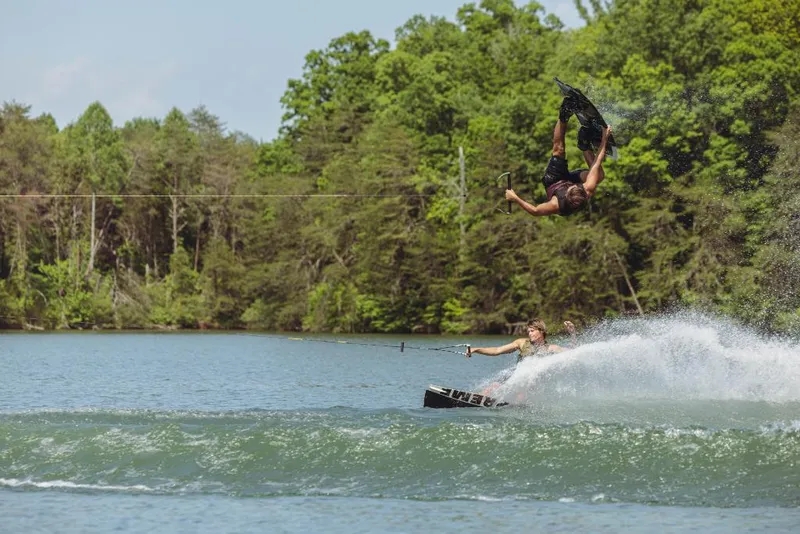Slide: The Image of Wakeboarder performing a flip behind a 2023 MasterCraft NXT24 boat on a lake. - 5
