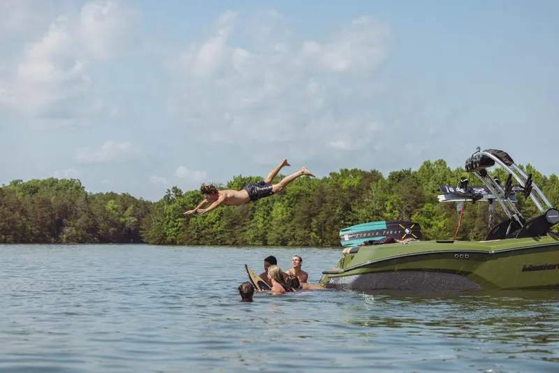 Slide: The Image of People enjoying water activities near a 2023 MasterCraft NXT24 boat. - 6