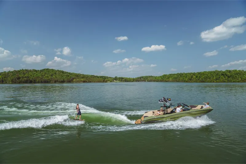 Slide: The Image of 2023 MasterCraft NXT24 boat towing a wakeboarder on a scenic lake. - 9