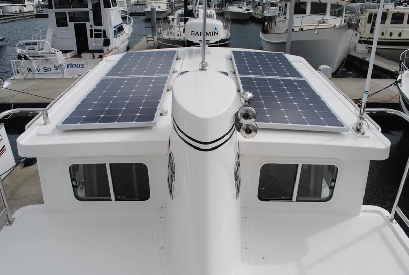 Slide: The Image of Nordic Tug 34 (2025) with solar panels on the roof, docked at a marina. - 2