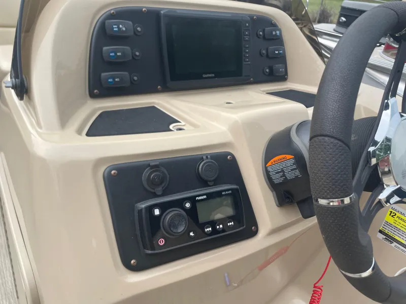 Slide: The Image of 2021 Manitou 230 Aurora LE boat dashboard with steering wheel and control panel. - 10