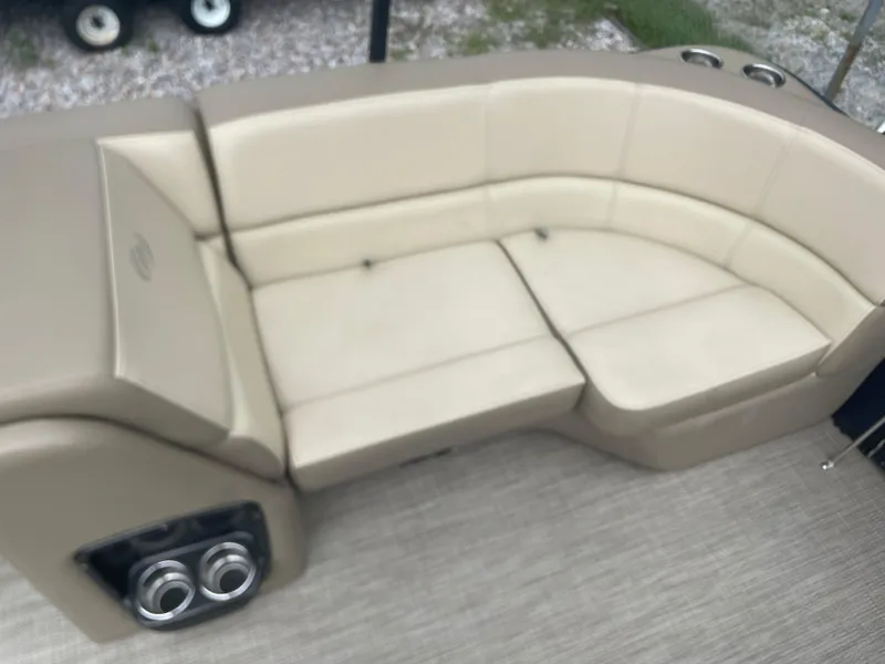Slide: The Image of 2021 Manitou 230 Aurora LE boat with beige seating and cup holders. - 11
