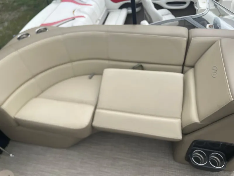 Slide: The Image of 2021 Manitou 230 Aurora LE boat with beige leather seating and cup holders. - 12