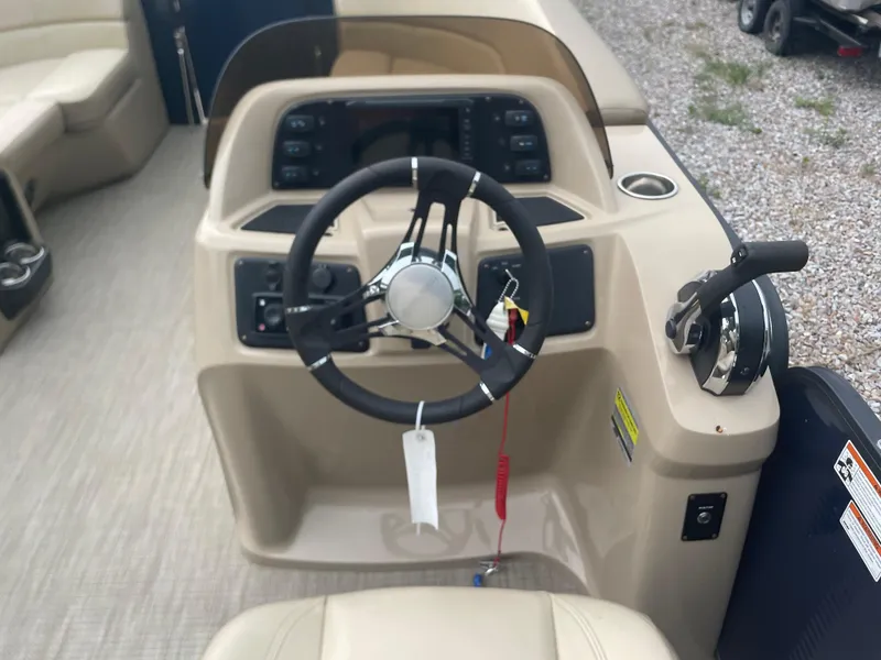 Slide: The Image of 2021 Manitou 230 Aurora LE boat helm with steering wheel and control panel. - 9