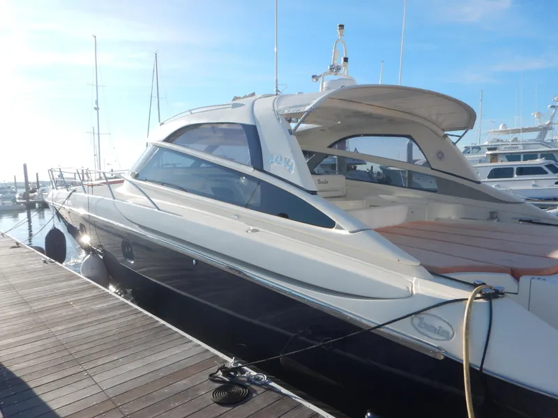 Slide: The Image of Luxury 2004 Baia 54 yacht docked at marina under clear blue sky. - 11