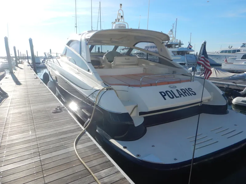 Slide: The Image of 2004 Baia 54 yacht docked at marina, rear view with "Polaris" name visible. - 12