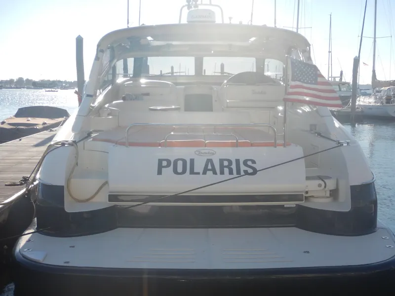 Slide: The Image of Rear view of 2004 Baia 54 yacht named Polaris, docked with American flag. - 13