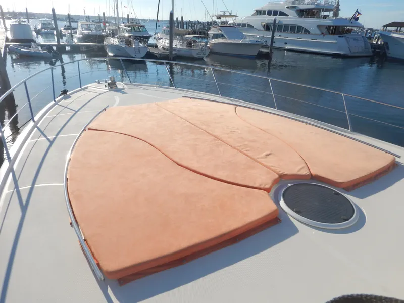 Slide: The Image of 2004 Baia 54 yacht with orange sunbathing cushions, docked at a marina. - 15