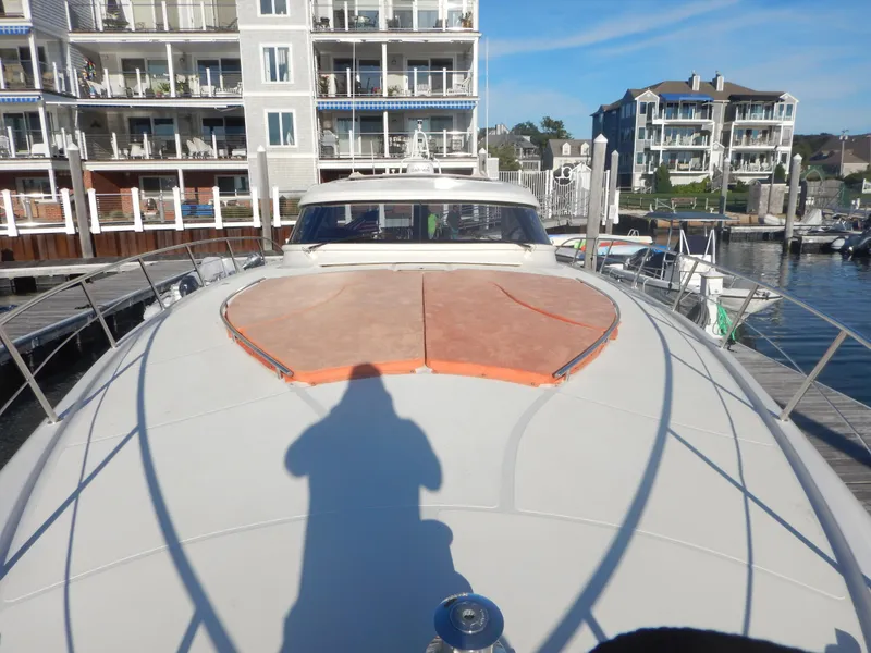 Slide: The Image of 2004 Baia 54 yacht docked at marina, with residential buildings in the background. - 16