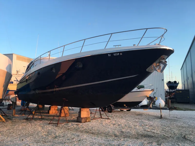 Slide: The Image of 2004 Baia 54 yacht on stands in a boatyard at sunset. - 27
