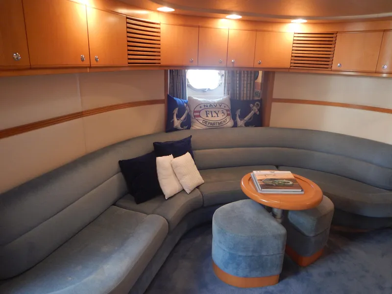 Slide: The Image of Luxurious 2004 Baia 54 yacht interior with curved seating, wooden cabinets, and nautical decor. - 33