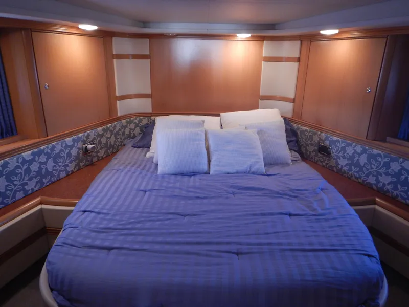 Slide: The Image of Luxurious cabin interior of 2004 Baia 54 yacht with cozy bedding and ambient lighting. - 35