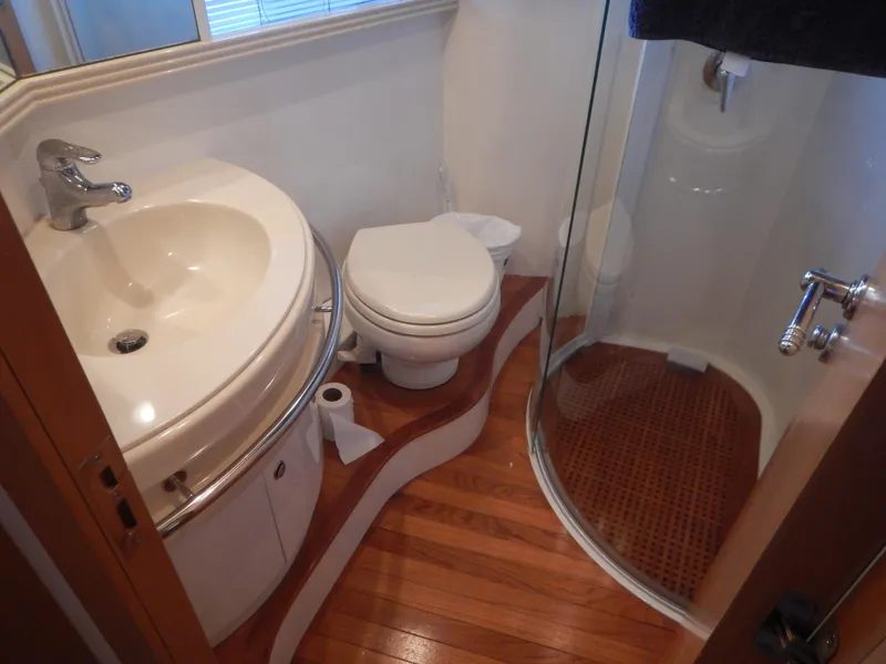 Slide: The Image of Luxurious 2004 Baia 54 yacht bathroom with curved sink, toilet, and glass shower. - 38
