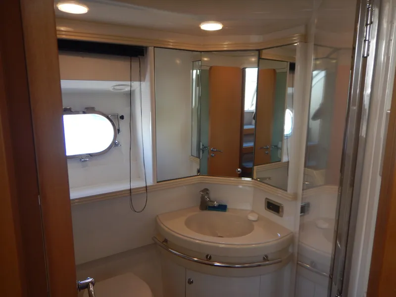 Slide: The Image of Luxurious bathroom interior of 2004 Baia 54 yacht with modern fixtures and porthole window. - 40