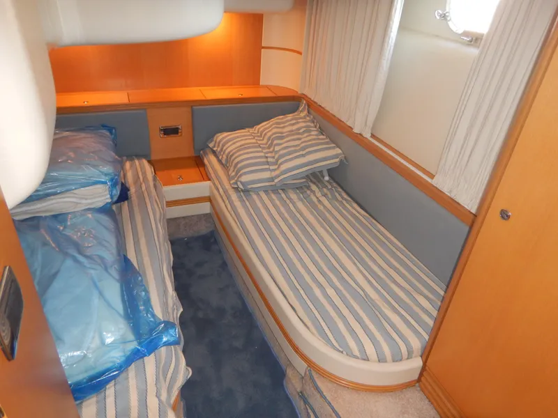 Slide: The Image of Cabin interior of 2004 Baia 54 yacht with twin striped beds and wooden accents. - 41